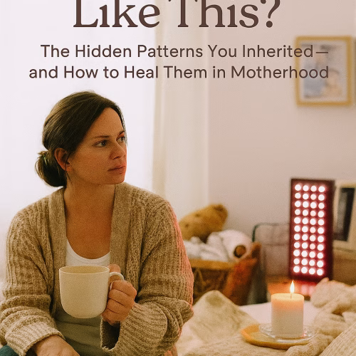 A light-skinned mother sits thoughtfully on the edge of a cozy, softly lit bed. She wears a beige cardigan and holds a warm mug in one hand, with a closed journal resting on her lap. A red light therapy panel glows gently nearby, alongside a flickering candle. In the background, children’s toys, a laundry basket, and a framed photo of older relatives hint at generational echoes. Overlay text reads: “Why Am I Like This? The Hidden Patterns You Inherited—and How to Heal Them in Motherhood.”